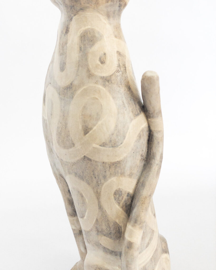 Ceramic cat glazed with a tangled swirly pattern in matte brown and beige glazes, close up of the back