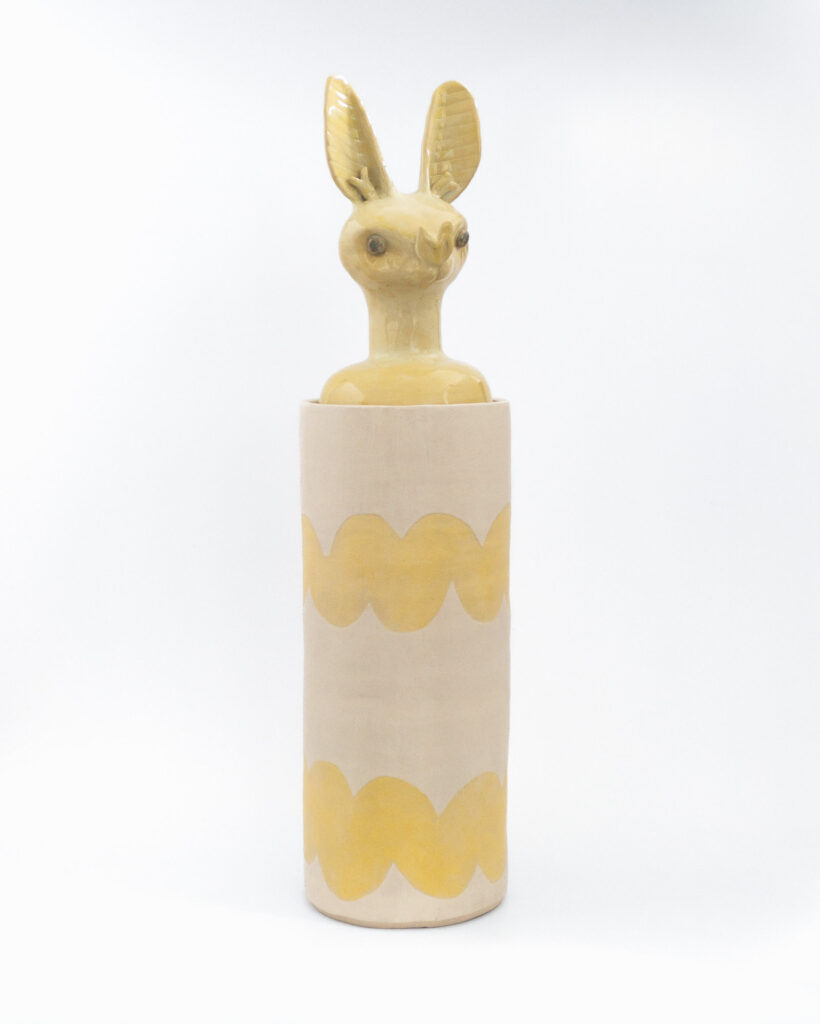 Cylindrical ceramic jar with a lid in the form of a yellow bat head, front view