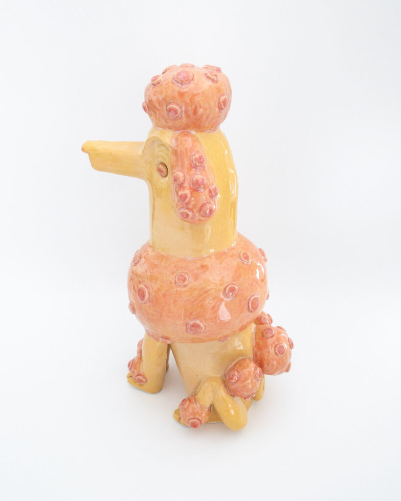 Ceramic poodle in pink and orange glazes, side view