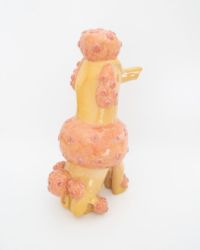 Ceramic poodle in pink and orange glazes, rear view