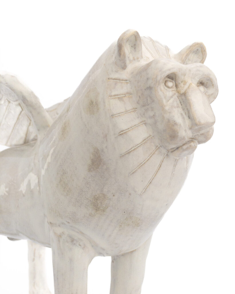 Winged ceramic lion in white glaze, close up of head
