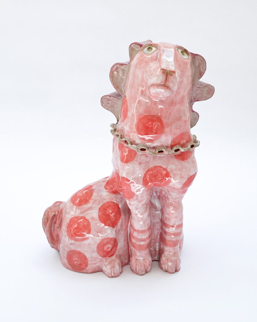 Ceramic sculpture of a quirky dog with pink glaze and darker pink spots