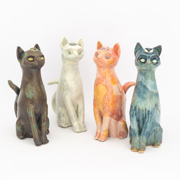 4 ceramic cats representing the elements and glazed accordingly: brown and green for earth, cloudy white for air, swirls of pink and orange for fire and drippy blues and greens for water