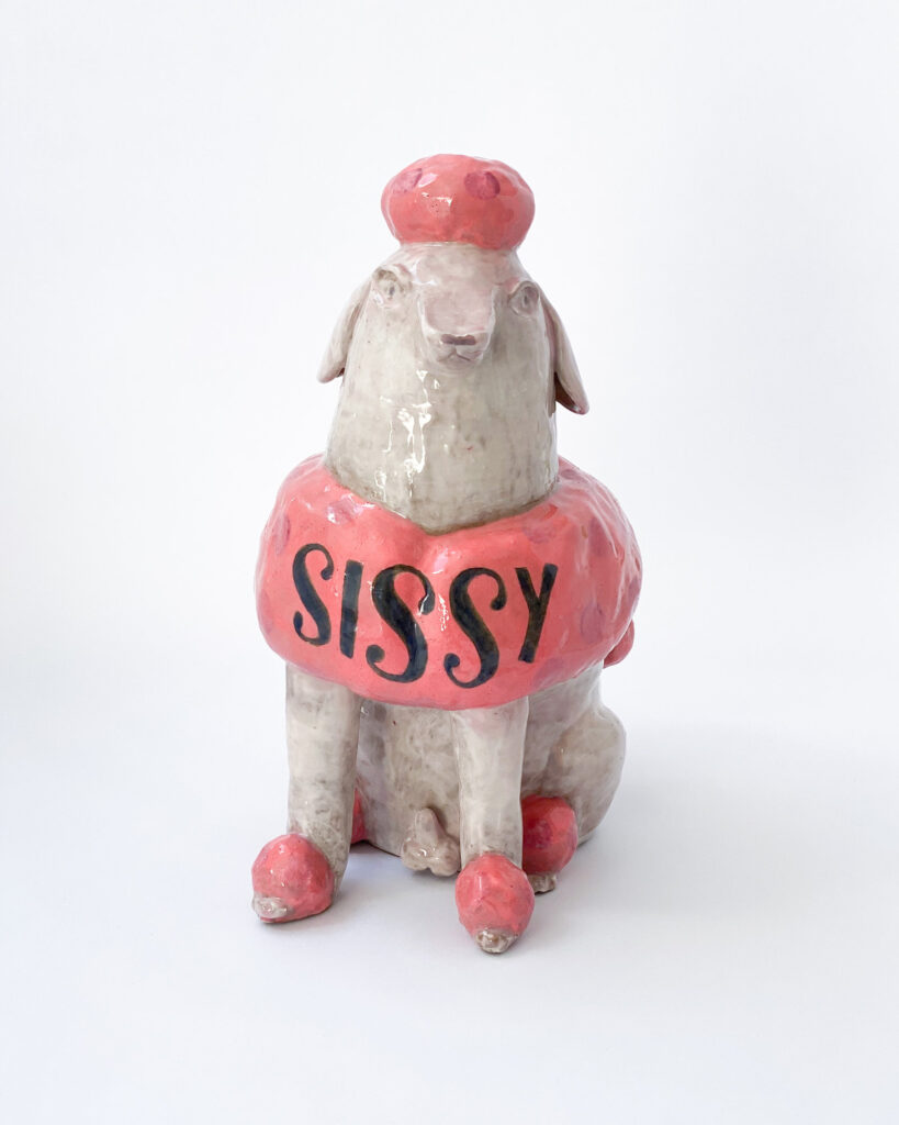 Ceramic poodle with pink fur and white skin, with Sissy written across his chest in blue letters