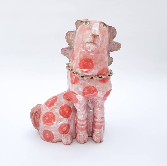 Ceramic sculpture of a quirky dog with pink glaze and darker pink spots