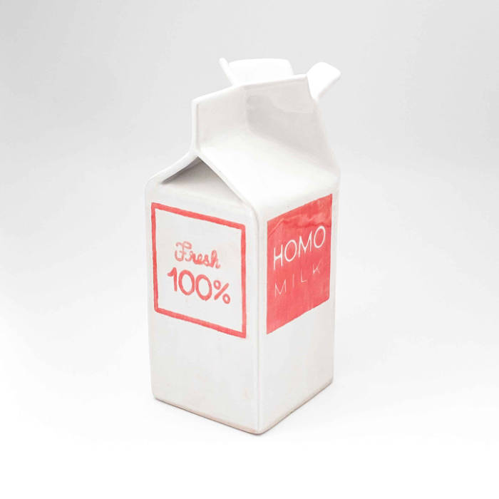 A ceramic milk carton with "Fresh 100%" on two sides and "Homo Milk" on the others