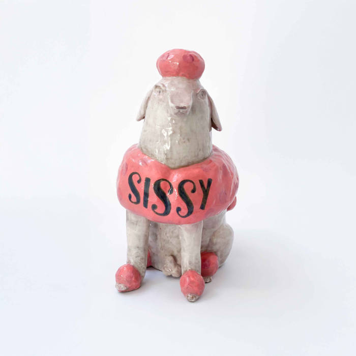 Ceramic sculpture of a poodle with white skin and pink fur, with "Sissy" emblazoned across his chest