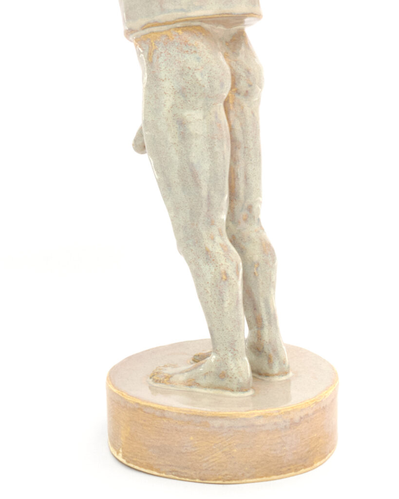 Reverse merman with fish head and man's legs, in an iridescent pearly glaze, viewed from the back