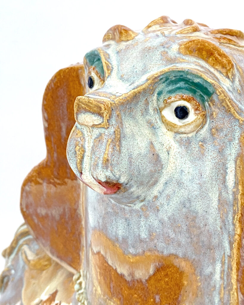 Close up of face of ceramic spaniel with eyeshadow and lipstick