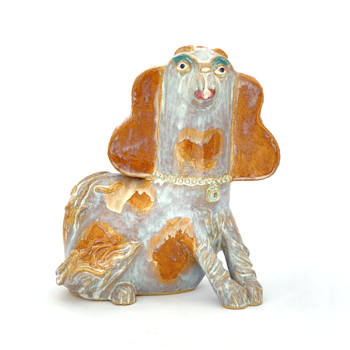 Ceramic sculpture of a spaniel in melty white and brown glazes, with eyeshadow and lipstick